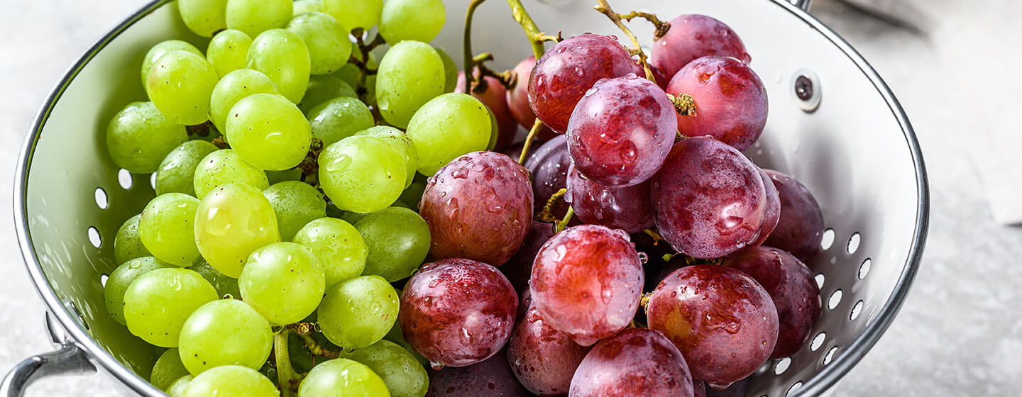 Red and green grapes in a colander