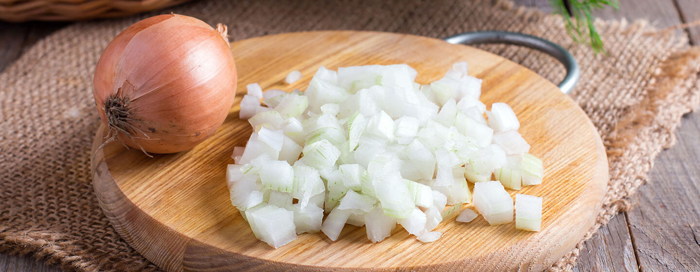 Raw onion, chopped very small cubes on a wooden board