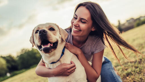 Owner hugging her yellow labrador